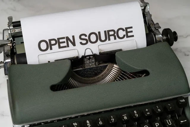 Close-up of a vintage typewriter with 'Open Source' typed on paper, conveying creativity. Recording competitor information from reliable sources